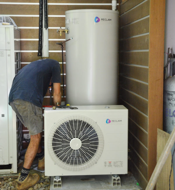 Person working on a heat pump hot water system.
